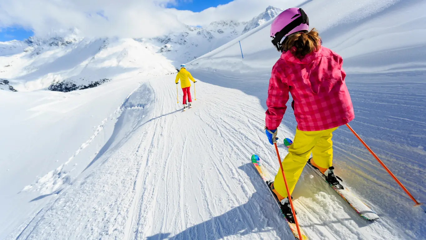 young child skiing down a well used slope