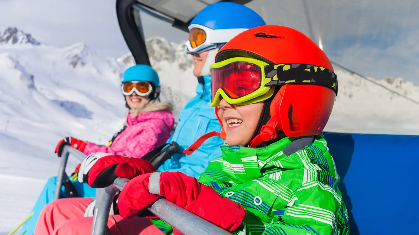 Family in a ski lift chair going up the slope