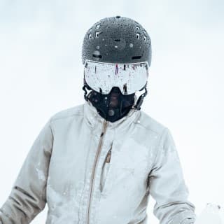 An unidentifiable man wearing grey skiwear and face completely covered 